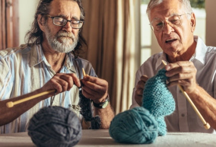 Photo de deux hommes d'âge mûr en train de tricoter