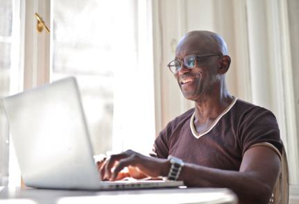 Senior écrivant sur un ordinateur