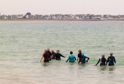 groupe de personnes réalisant du longe-côte en mer