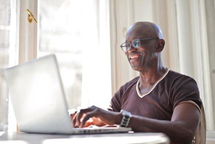 Senior écrivant sur un ordinateur